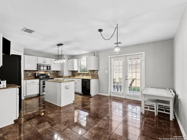a open kitchen with white cabinets and stainless steel appliances