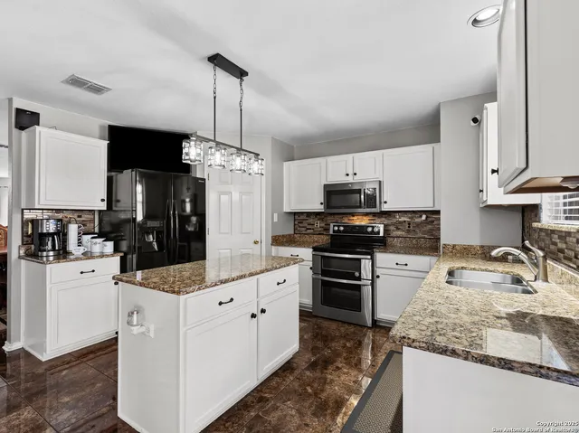 a kitchen with stainless steel appliances granite countertop a sink stove and refrigerator