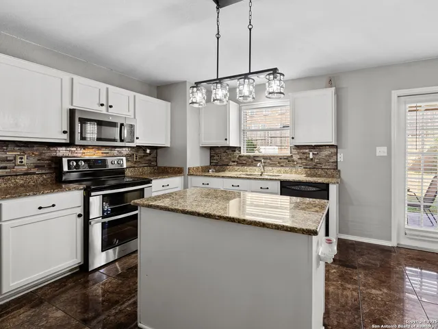 a kitchen with stainless steel appliances granite countertop a sink a stove a oven a kitchen island with cabinets and wooden floor