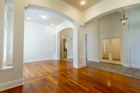 a view of a livingroom with wooden floor and a bathroom