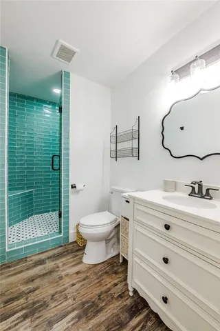 a bathroom with a toilet a sink and glass door