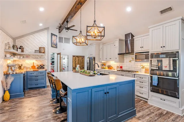 a kitchen with cabinets and wooden floor