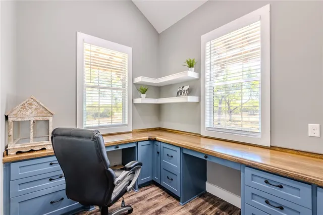 a view of a workspace with furniture and a window