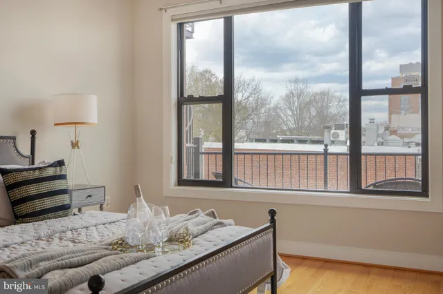 a bedroom with a bed and a large window