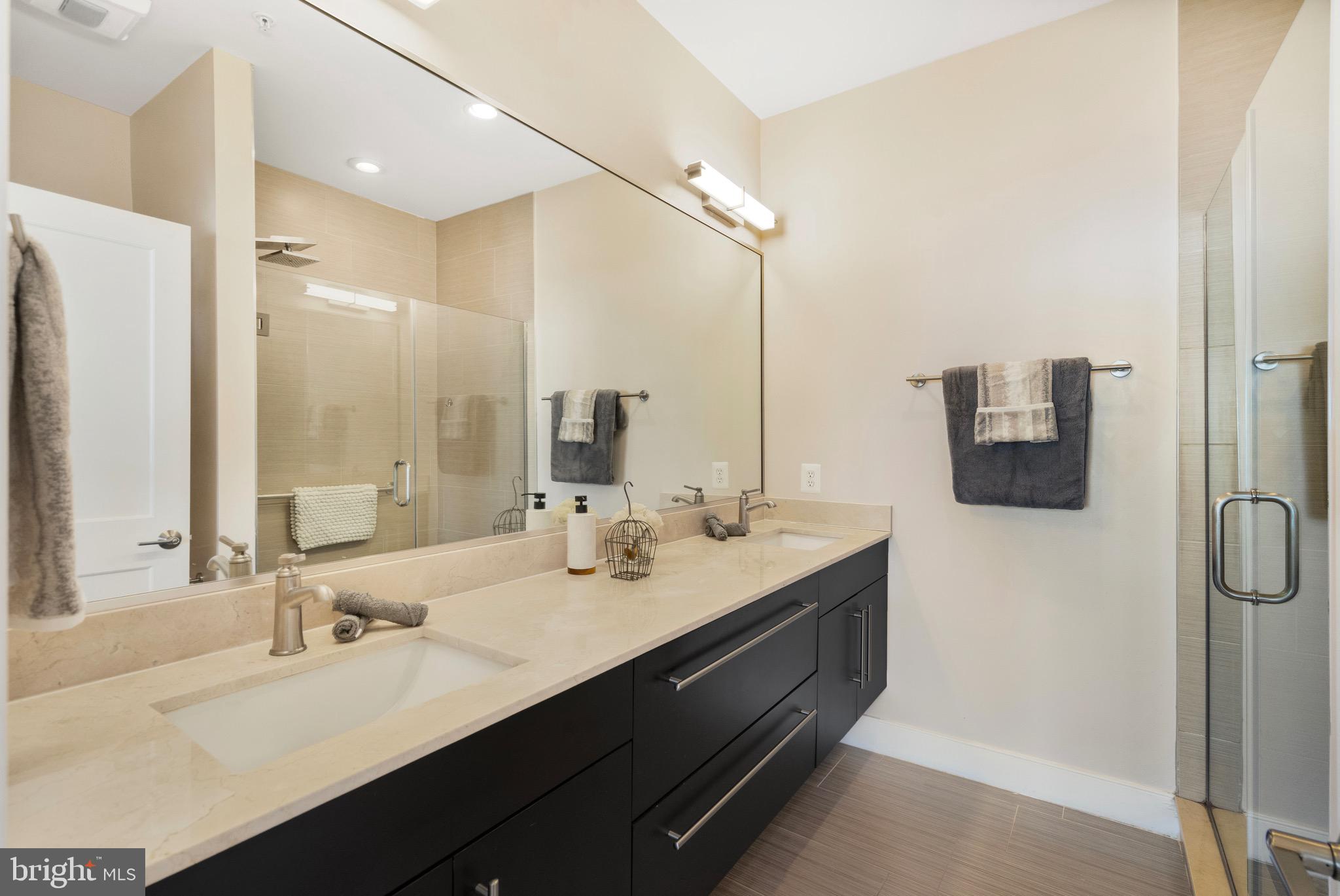 1402 K Street Southeast, Unit 2 Washington, DC 20003 - Photo 25 of 32 a bathroom with a double vanity sink a mirror and shower