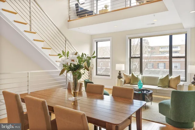 a view of a dining room with furniture a potted plant and wooden floor