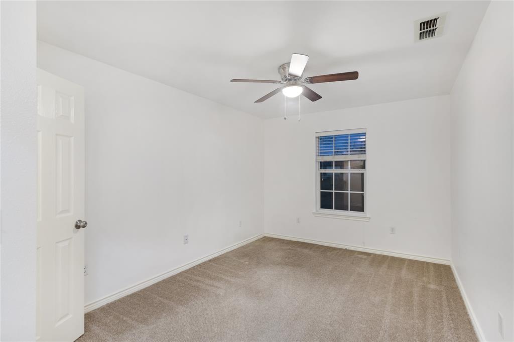 1021 Rice Street, Unit 102 Denison, TX 75020 - Photo 15 of 18 an empty room with a window and ceiling fan