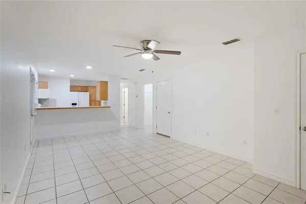a view of an empty room and kitchen view