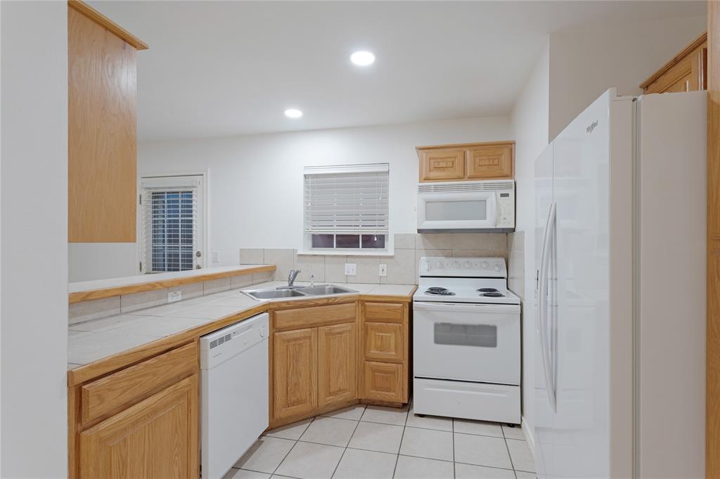 1021 Rice Street, Unit 102 Denison, TX 75020 - Photo 9 of 18 a kitchen with a sink stove and cabinets