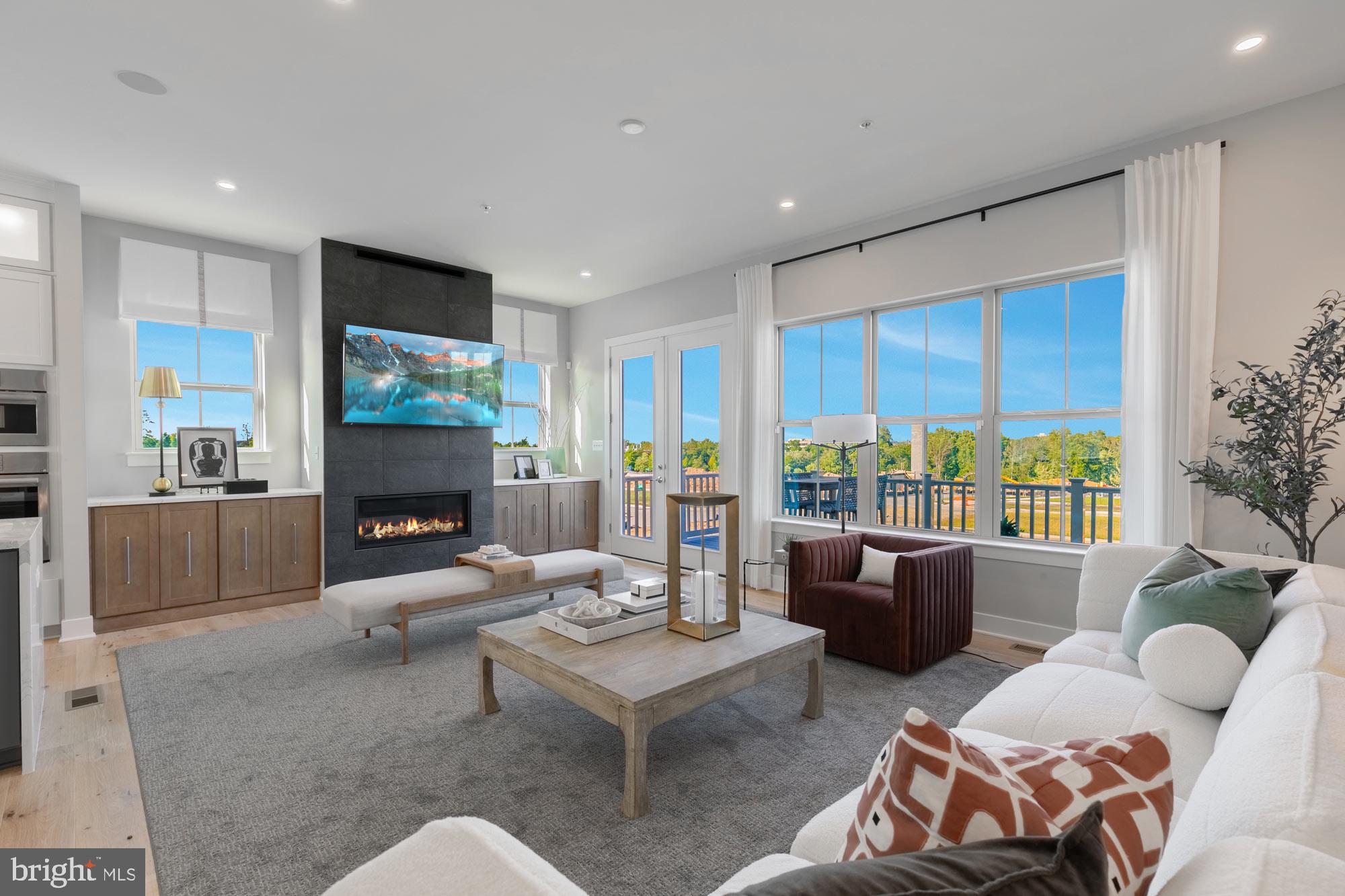 14917 Dispatch Street Rockville, MD 20850 - Photo 4 of 29 a living room with furniture a flat screen tv and a floor to ceiling window