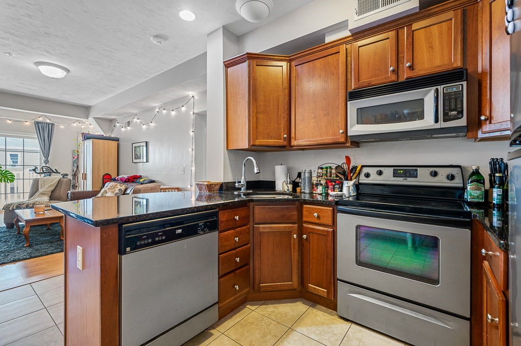 50 Adams Street, Unit 101 Worcester, MA 01604 - Photo 4 of 20 a kitchen with stainless steel appliances granite countertop a stove sink and cabinets