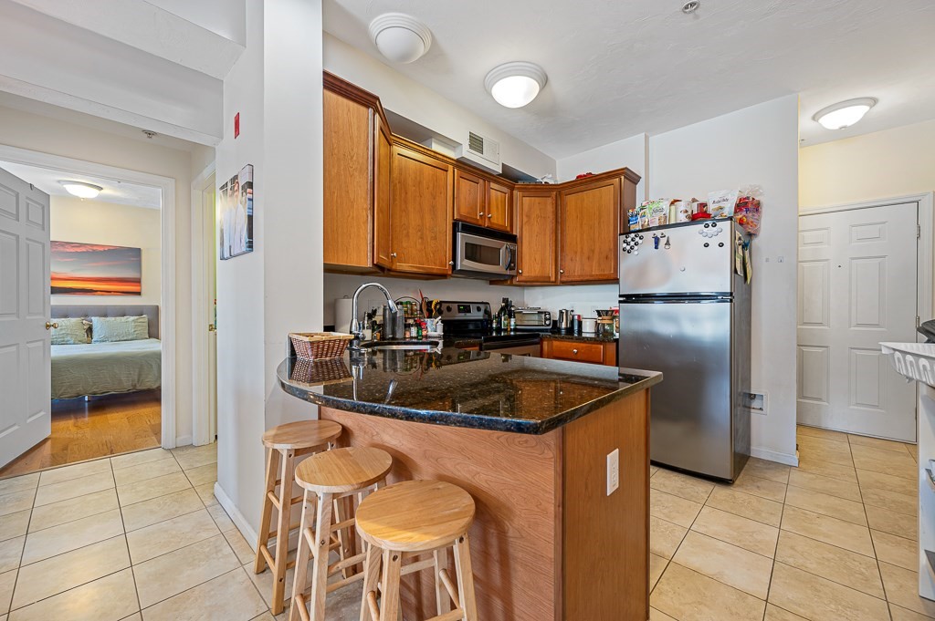 50 Adams Street, Unit 101 Worcester, MA 01604 - Photo 5 of 20 a kitchen with a sink refrigerator and microwave