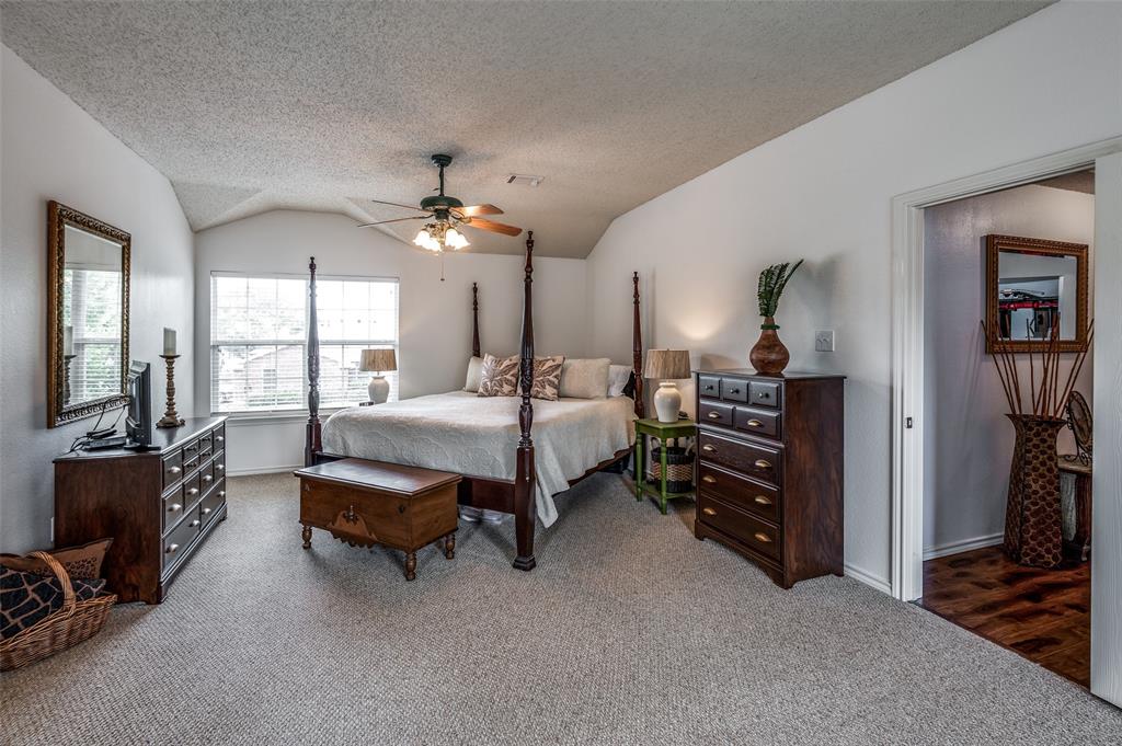 8606 Scooner Street Rowlett, TX 75089 - Photo 14 of 30 a spacious bedroom with a bed a chandelier and a large window