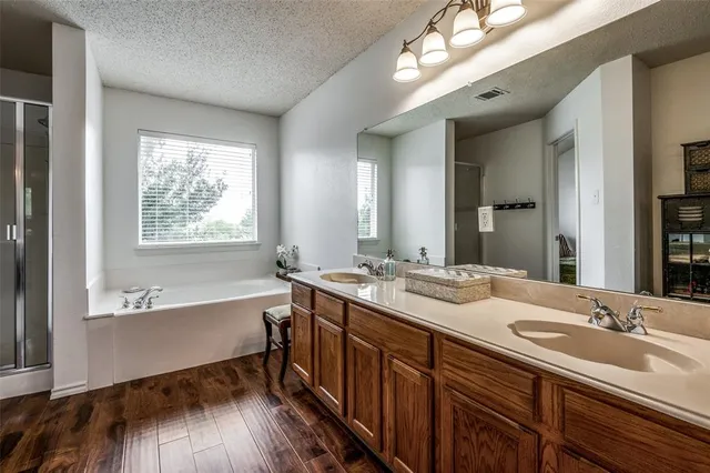 a bathroom with a tub double vanity sink and mirror