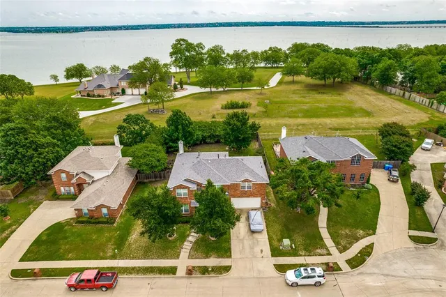 an aerial view of residential houses with outdoor space and lake view