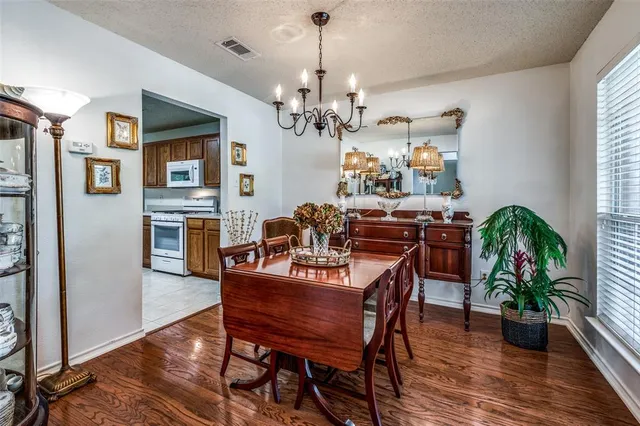 a view of a dining room with furniture a chandelier and wooden floor