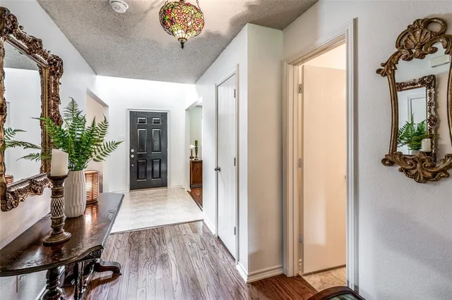 a view of a hallway to a livingroom and a dining room with furniture wooden floor