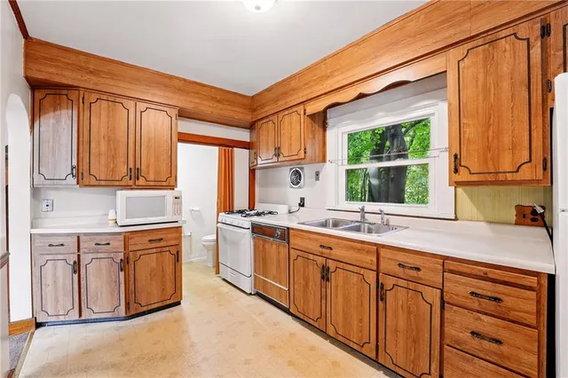 a kitchen with stainless steel appliances granite countertop a sink a stove and cabinets