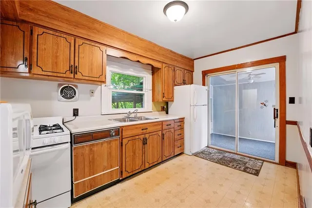 a kitchen with stainless steel appliances granite countertop a refrigerator a stove and white cabinets with wooden floor