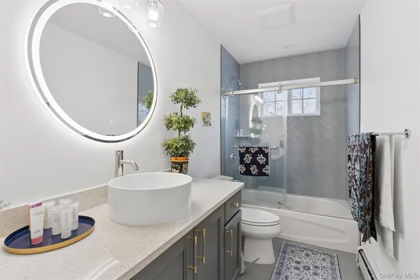 a bathroom with a sink a toilet and shower