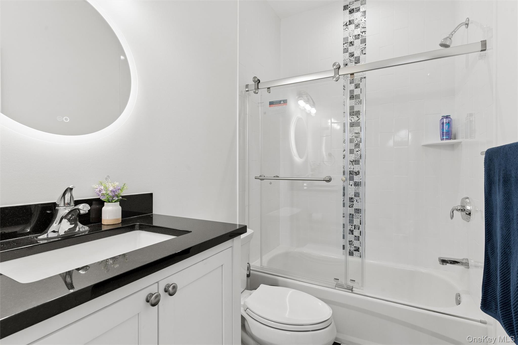 16 Gateway Court Hampton Bays, NY 11946 - Photo 27 of 30 a bathroom with a granite countertop sink a toilet and shower