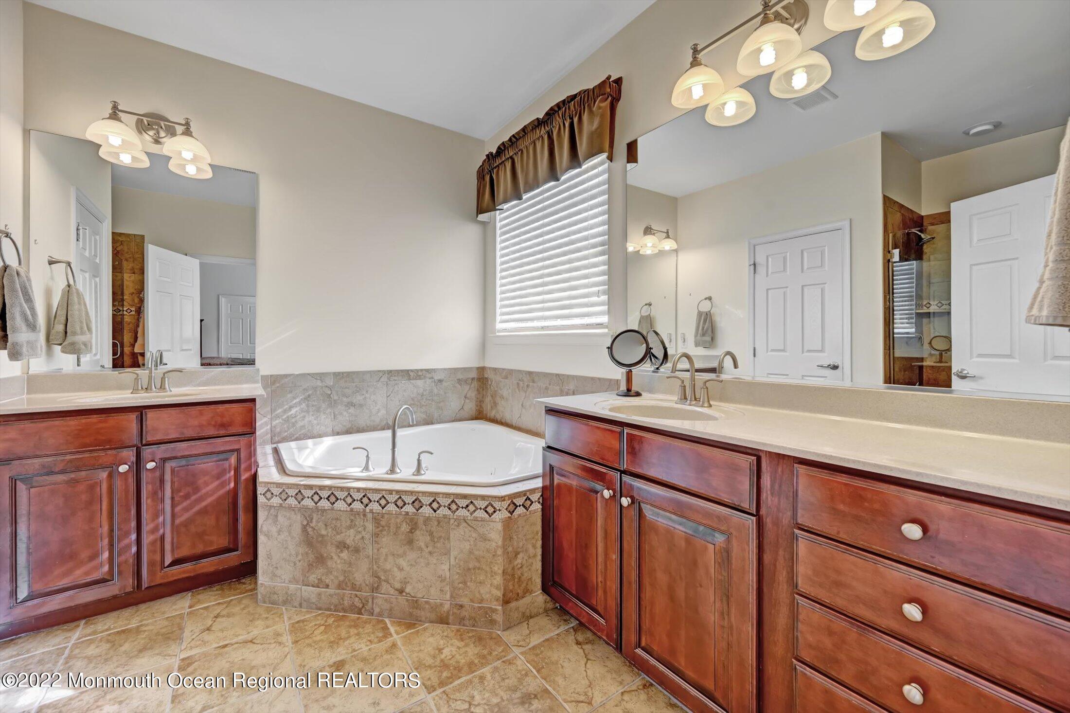 20 East Francesa Court Farmingdale, NJ 07727 - Photo 26 of 78 a spacious bathroom with a granite countertop sink a large mirror and bathtub