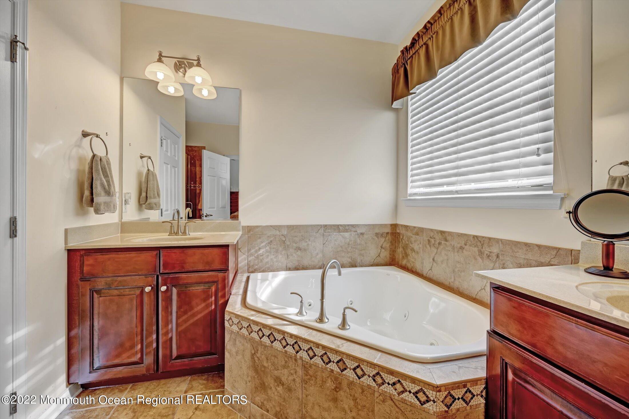 20 East Francesa Court Farmingdale, NJ 07727 - Photo 27 of 78 a bathroom with a granite countertop sink a mirror and a bathtub