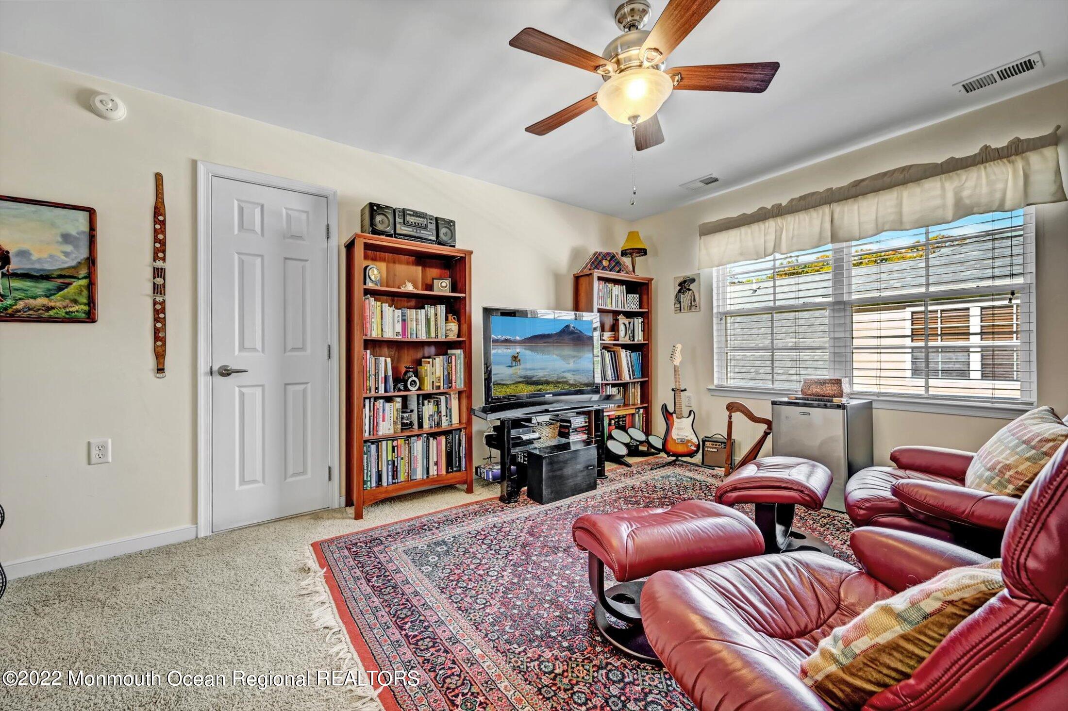 20 East Francesa Court Farmingdale, NJ 07727 - Photo 33 of 78 a living room with furniture a bookshelf and a window