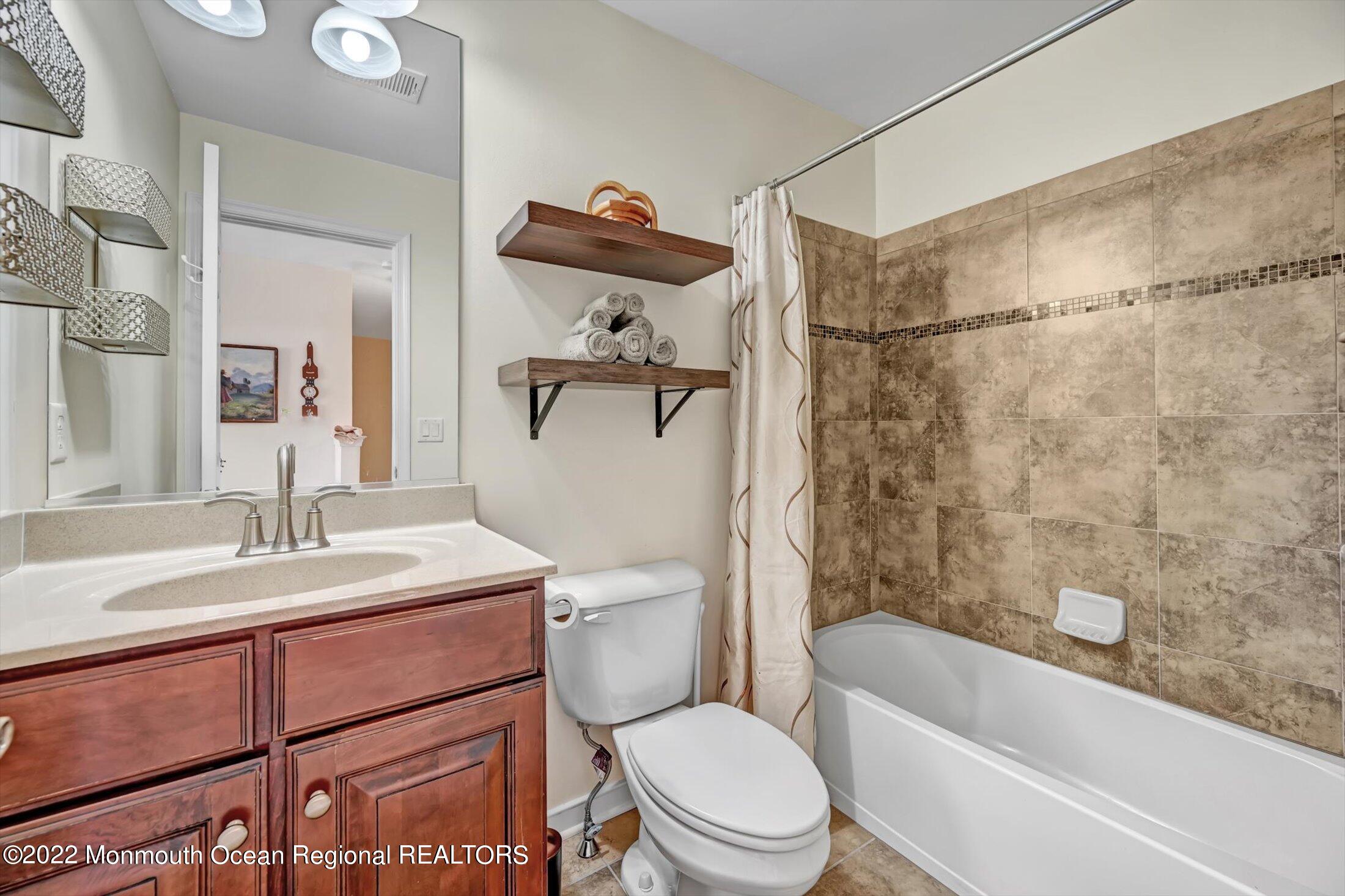 20 East Francesa Court Farmingdale, NJ 07727 - Photo 34 of 78 a bathroom with a sink toilet vanity and shower