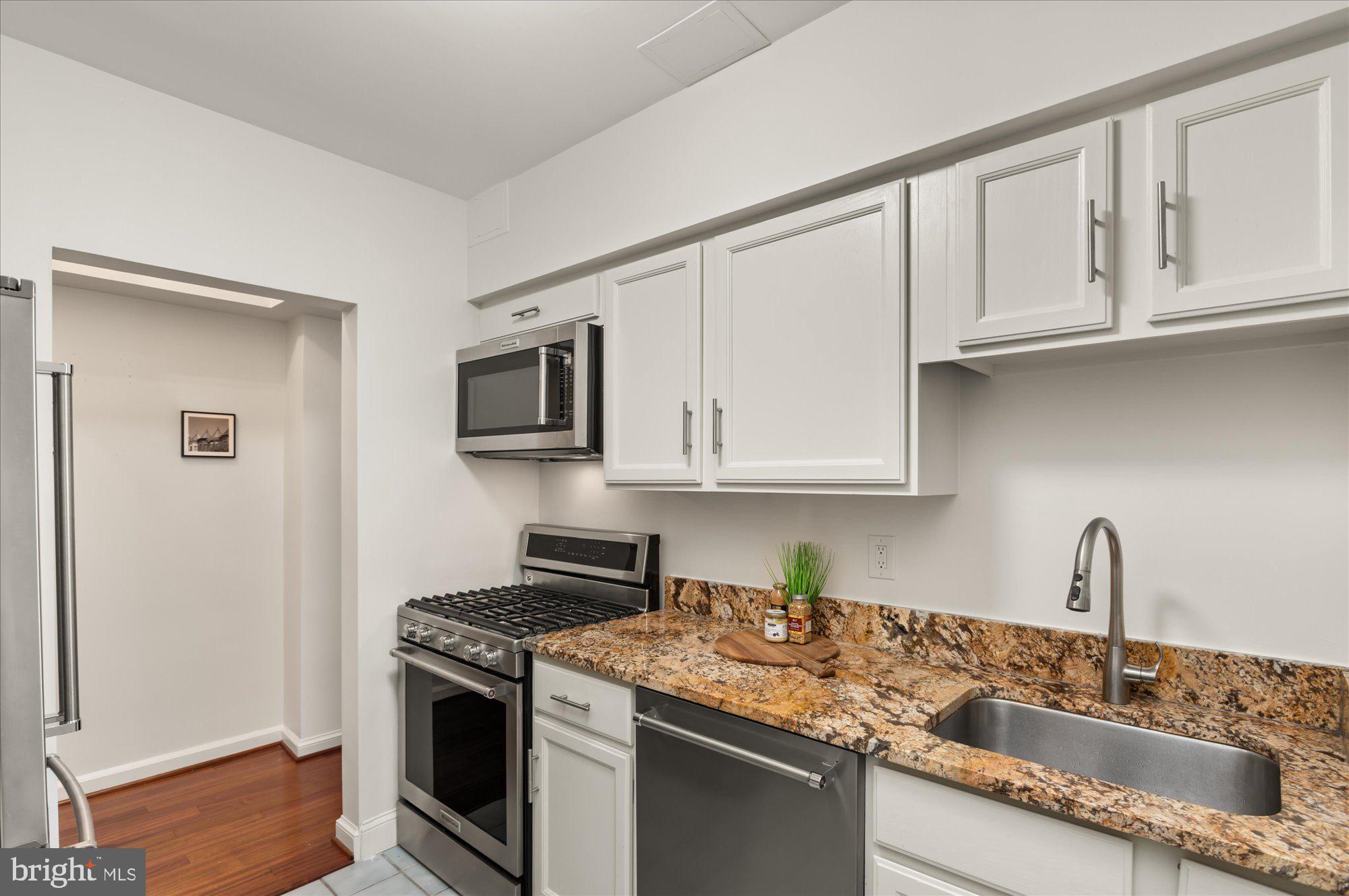 2101 Connecticut Avenue Northwest, Unit A Washington, DC 20009 - Photo 6 of 34 a kitchen with stainless steel appliances granite countertop a sink stove and microwave