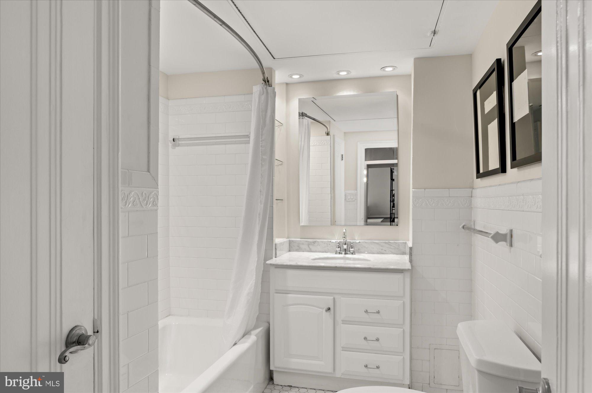 2101 Connecticut Avenue Northwest, Unit A Washington, DC 20009 - Photo 9 of 34 a bathroom with a double vanity sink a mirror and a bathtub