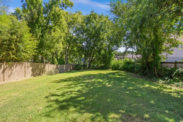 a backyard of a house with trees and plants