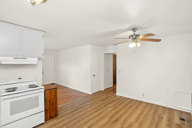 a view of a kitchen with a sink wooden floor and cabinets