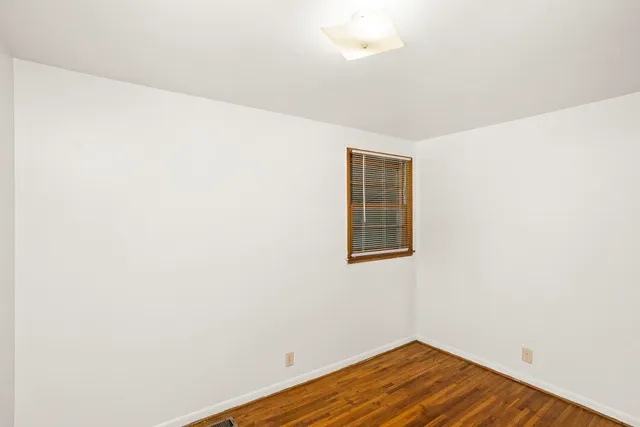 a view of a room with wooden floor and white walls