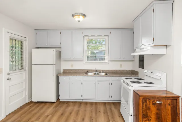 a kitchen with cabinets appliances a sink and a window
