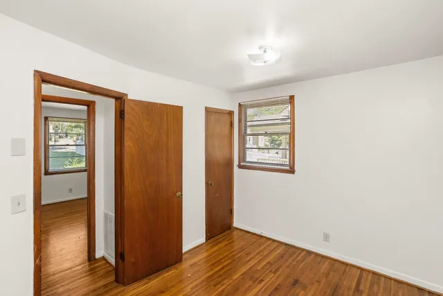 a view of an empty room with wooden floor