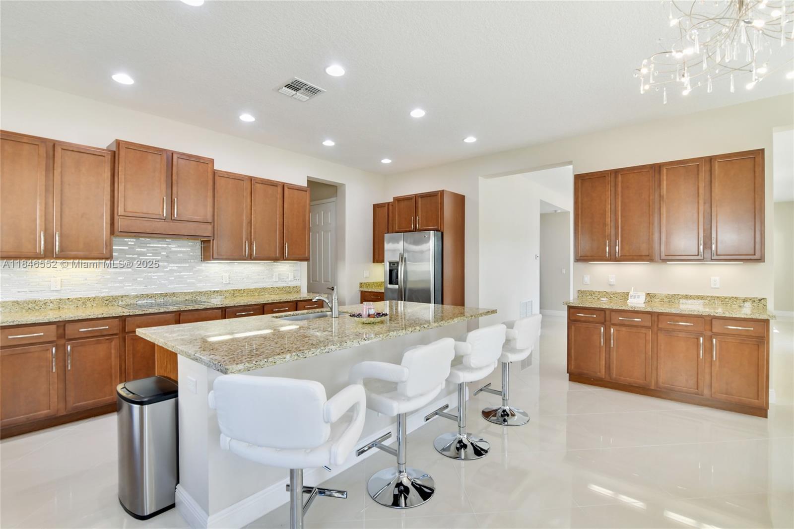 12137 Boca Reserve Lane Boca Raton, FL 33428 - Photo 2 of 35 a kitchen with granite countertop sink cabinets and refrigerator