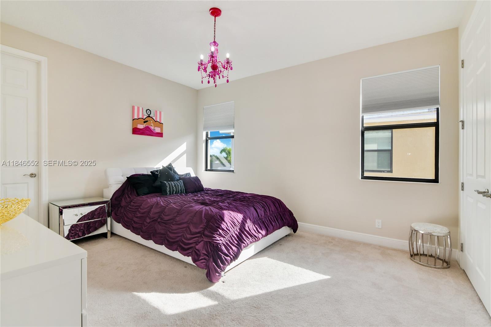 12137 Boca Reserve Lane Boca Raton, FL 33428 - Photo 21 of 35 a bedroom with a bed and a chandelier