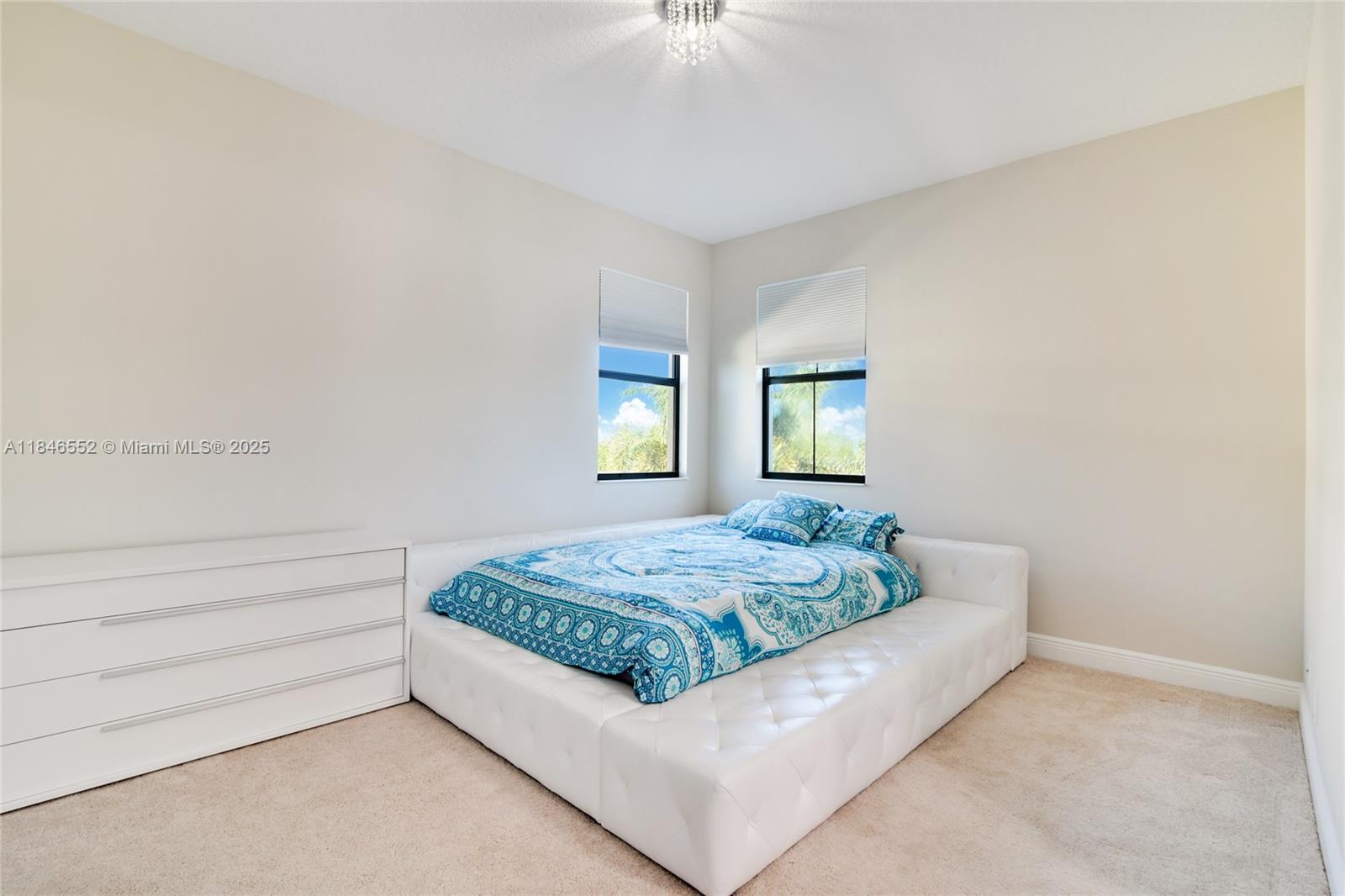 12137 Boca Reserve Lane Boca Raton, FL 33428 - Photo 23 of 35 a living room with a bed and a chandelier