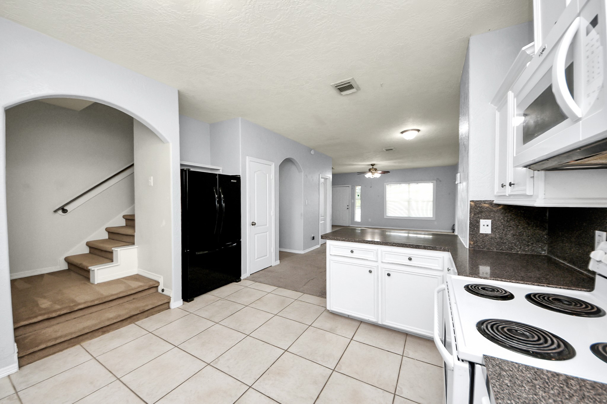 21940 Rayford Road, Unit B Humble, TX 77338 - Photo 12 of 38 a kitchen with a sink a refrigerator and cabinets