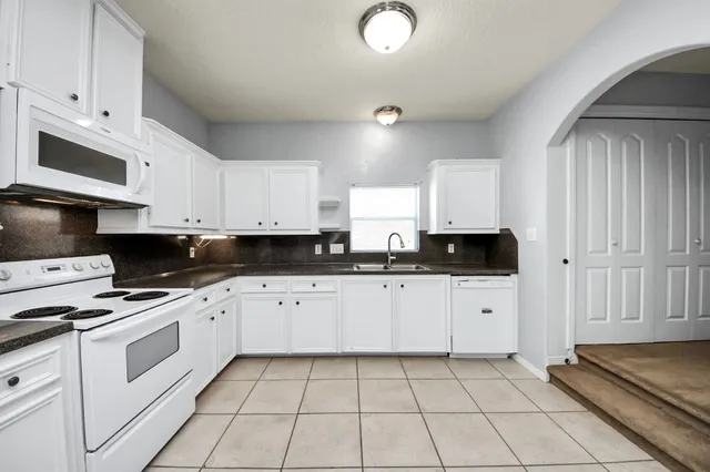 a kitchen with stainless steel appliances a sink a stove a microwave and cabinets