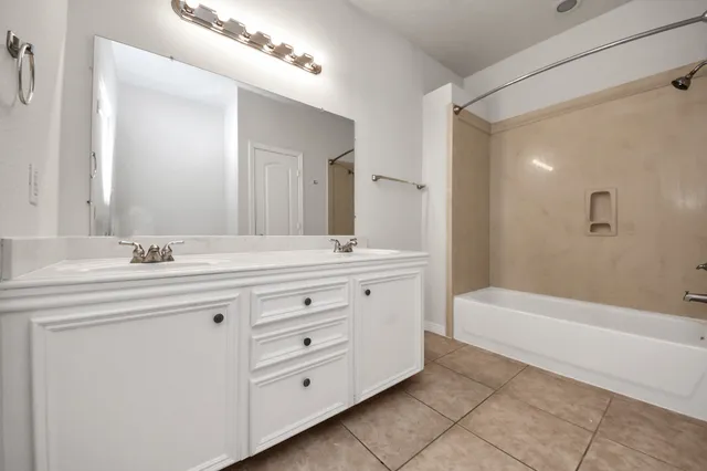 a bathroom with a sink double vanity and tub