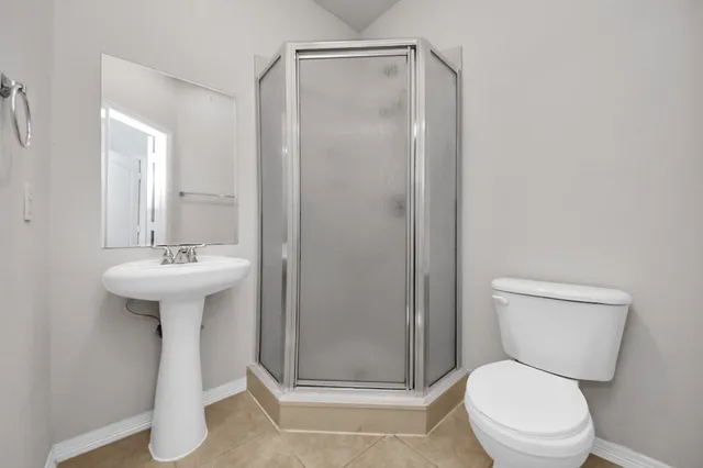 a bathroom with a sink a toilet a mirror and shower