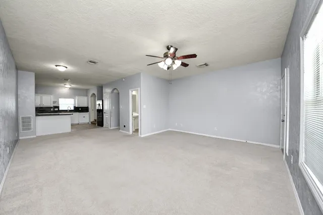 a view of an empty room with a kitchen