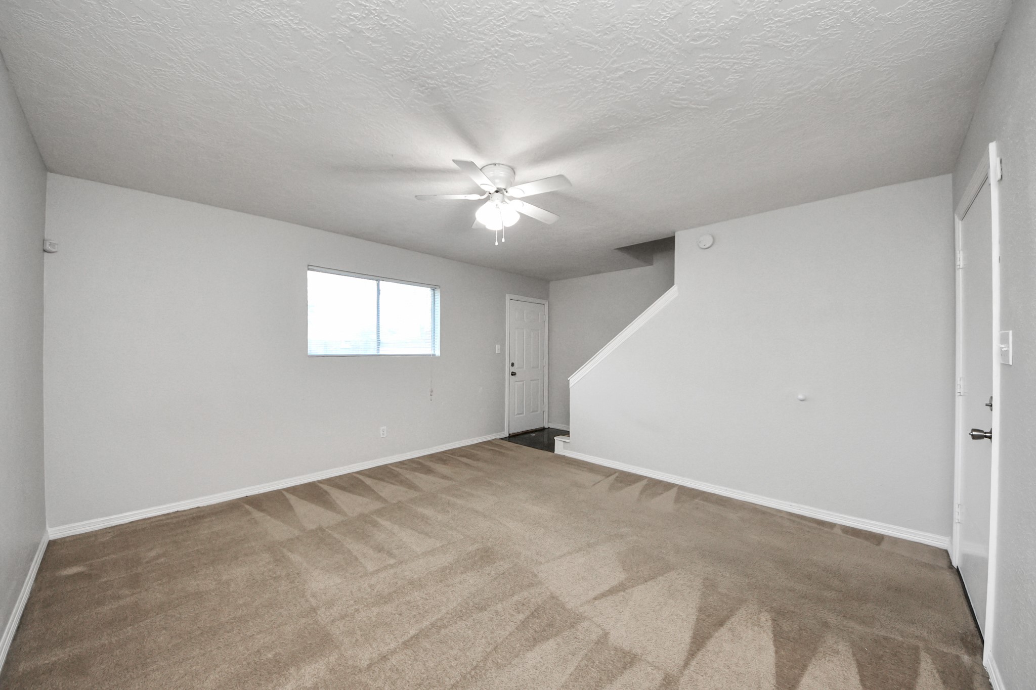 21940 Rayford Road, Unit B Humble, TX 77338 - Photo 32 of 38 an empty room with windows and chandelier fan