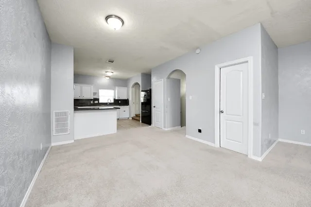 a view of a kitchen with refrigerator and white cabinets