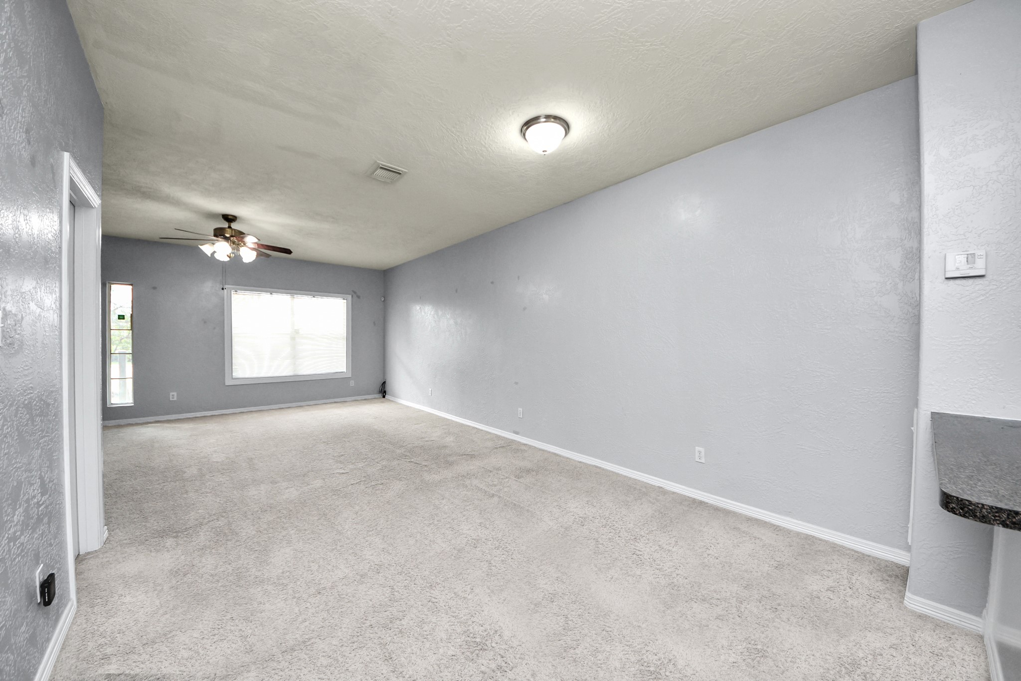 21940 Rayford Road, Unit B Humble, TX 77338 - Photo 7 of 38 a view of a big room with windows and chandelier fan