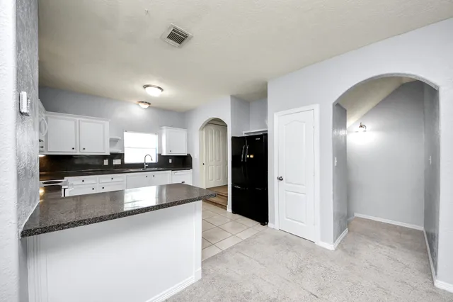a large kitchen with stainless steel appliances granite countertop a refrigerator and a stove