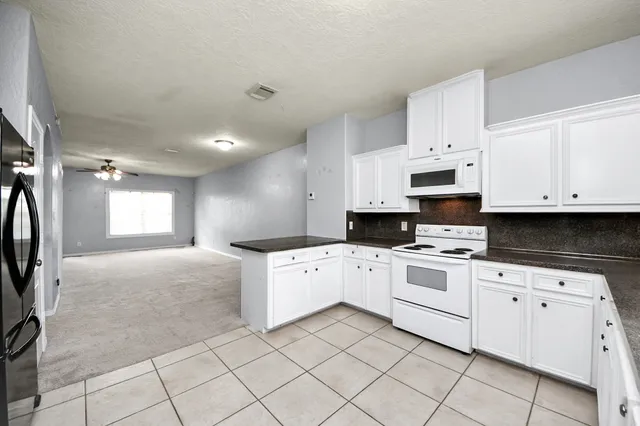 a kitchen with white cabinets and white appliances