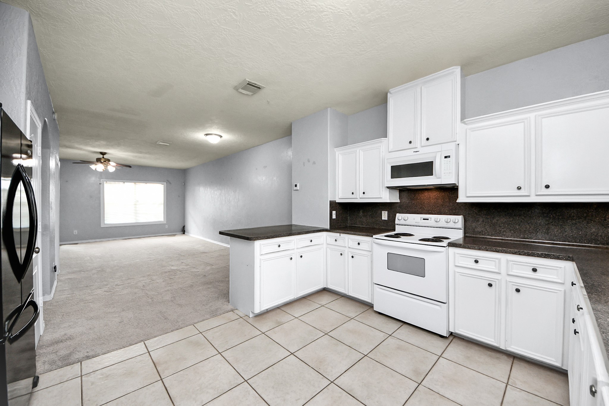 21940 Rayford Road, Unit B Humble, TX 77338 - Photo 10 of 38 a kitchen with white cabinets and white appliances